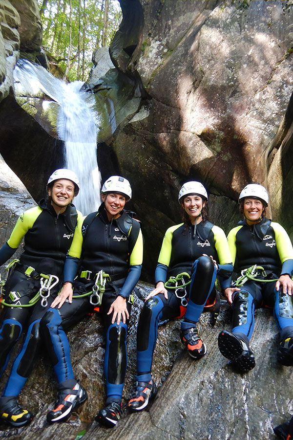 Gruppe von vier Frauen beim Canyoning im Tessin vor einem Wasserfall – nachhaltiges Outdoor-Abenteuer mit purelements®